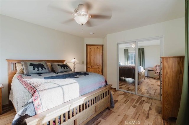 bedroom with ceiling fan, light hardwood / wood-style floors, and a closet