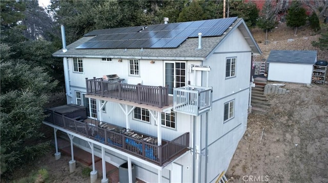 exterior space featuring roof mounted solar panels, a shingled roof, a balcony, and central AC unit