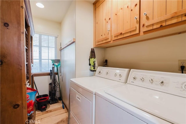 laundry area featuring washer and dryer, cabinets, and light hardwood / wood-style floors