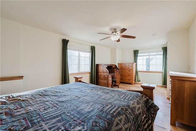 bedroom featuring multiple windows, ceiling fan, and light wood-type flooring