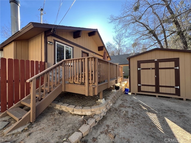 view of side of property featuring a deck and a storage unit