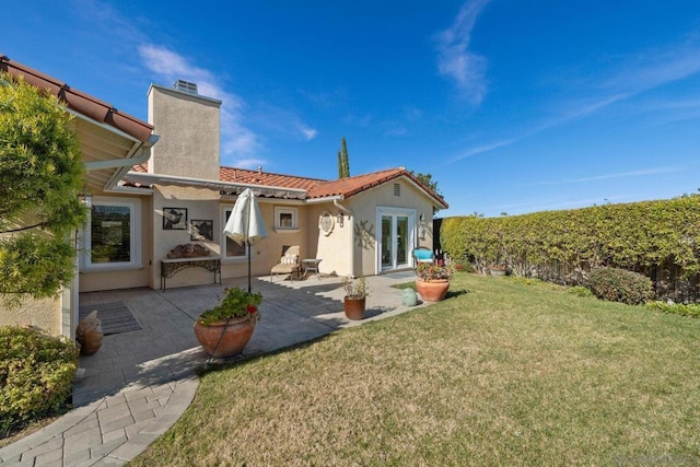 rear view of house featuring a yard and a patio