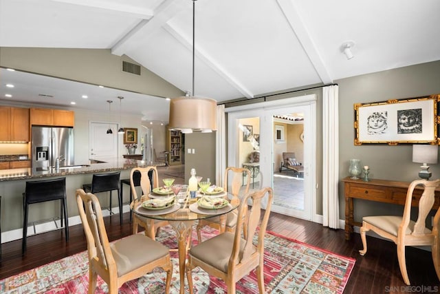 dining space featuring sink, vaulted ceiling with beams, and dark wood-type flooring