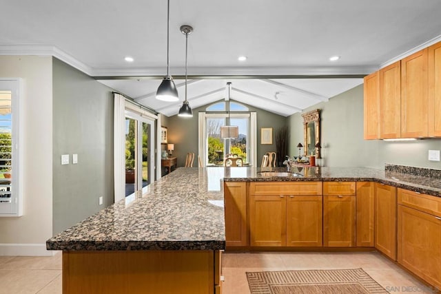 kitchen featuring dark stone countertops, a center island, vaulted ceiling with beams, sink, and decorative light fixtures