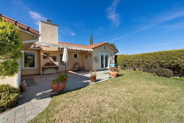 rear view of property with a patio area and a yard