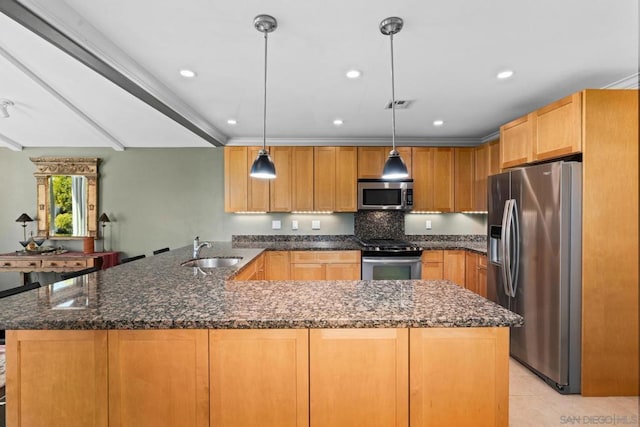 kitchen featuring sink, dark stone countertops, kitchen peninsula, hanging light fixtures, and appliances with stainless steel finishes