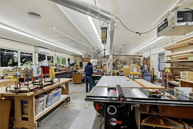 interior space featuring a wall mounted AC and a workshop area