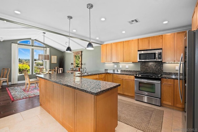 kitchen with pendant lighting, stainless steel appliances, backsplash, dark stone counters, and sink