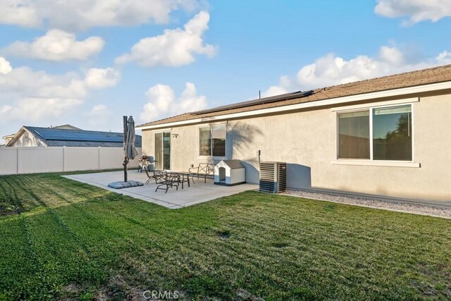 rear view of property featuring a lawn, central AC, and a patio