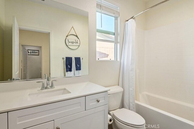 full bathroom featuring toilet, shower / tub combo with curtain, and vanity