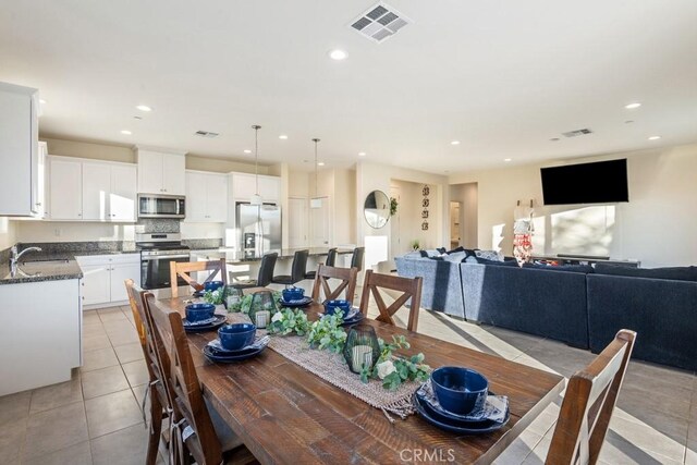 dining space with light tile patterned floors and sink