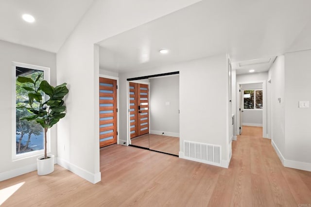 unfurnished bedroom with light wood-type flooring and vaulted ceiling