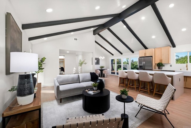 living room with high vaulted ceiling, light hardwood / wood-style floors, and beamed ceiling