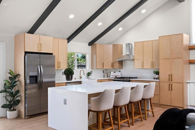 kitchen with stainless steel appliances, light hardwood / wood-style floors, high vaulted ceiling, a kitchen island, and wall chimney range hood