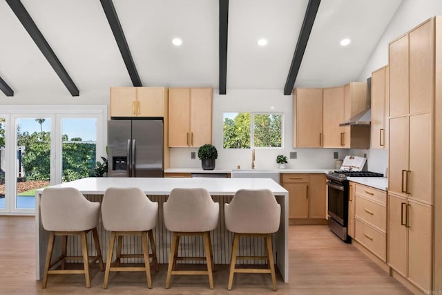 kitchen featuring sink, stainless steel appliances, a center island, and light brown cabinets