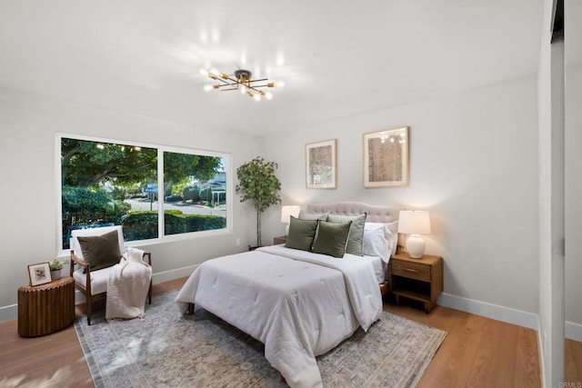 bedroom featuring hardwood / wood-style floors and a chandelier