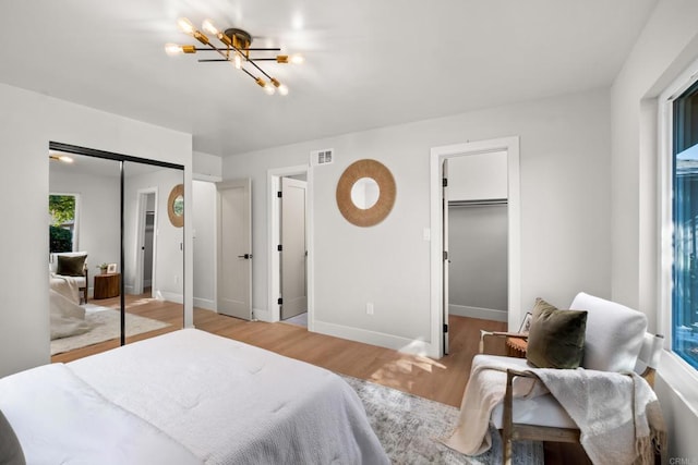 bedroom with light hardwood / wood-style flooring and an inviting chandelier