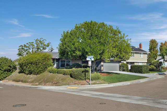 view of property hidden behind natural elements featuring a garage