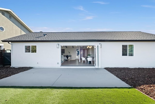 back of house featuring a lawn and a patio