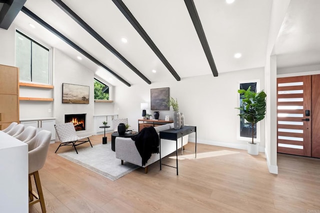 living room with lofted ceiling with beams and light hardwood / wood-style flooring