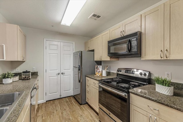 kitchen featuring light wood-type flooring, appliances with stainless steel finishes, and light brown cabinets