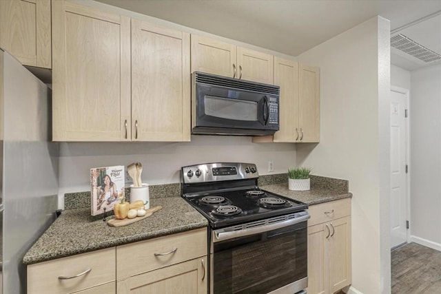 kitchen featuring dark stone counters, stainless steel range with electric cooktop, light brown cabinetry, and wood-type flooring