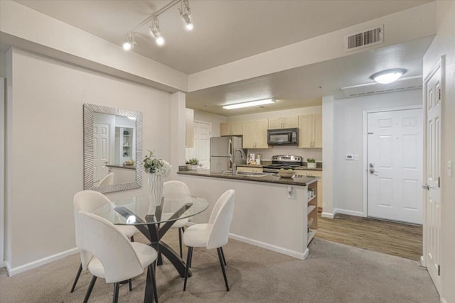 dining area with sink and light carpet