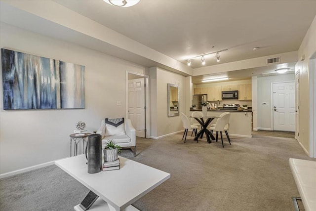 living room with track lighting and light carpet