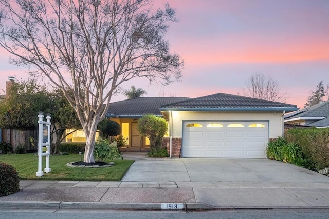 view of front of property with a yard and a garage