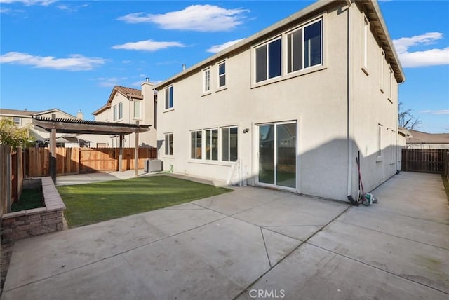 back of property with a patio area, a yard, and a pergola