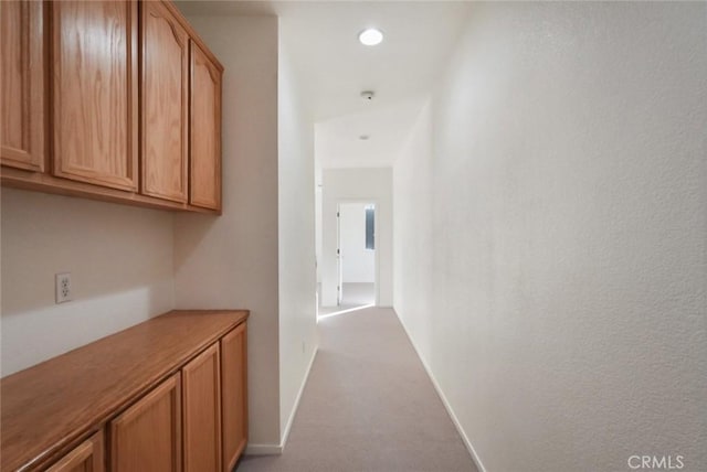 hallway with light colored carpet