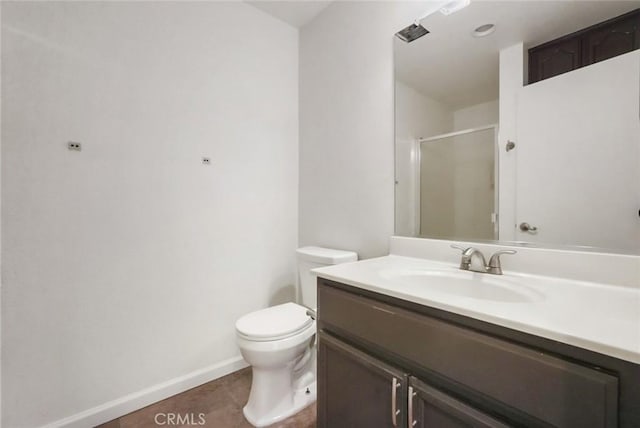 bathroom with a shower with shower door, tile patterned floors, toilet, and vanity