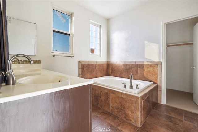 bathroom featuring tile patterned flooring, sink, and tiled tub