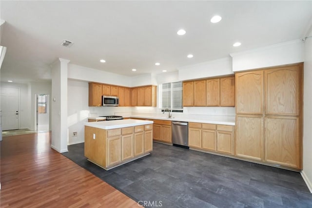 kitchen with dark hardwood / wood-style floors, a kitchen island, sink, crown molding, and stainless steel appliances