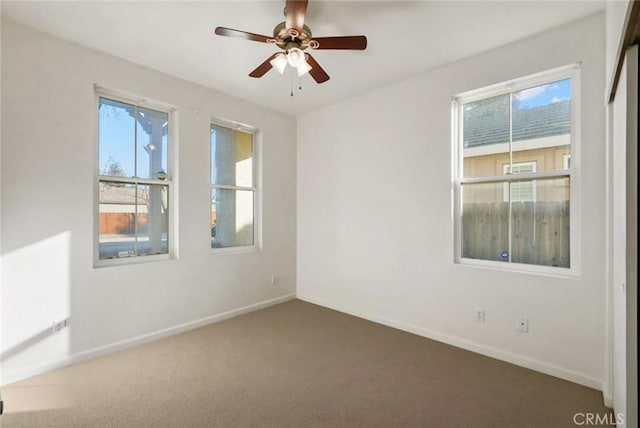 carpeted spare room featuring ceiling fan