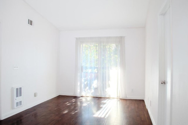 unfurnished room featuring vaulted ceiling and dark hardwood / wood-style flooring