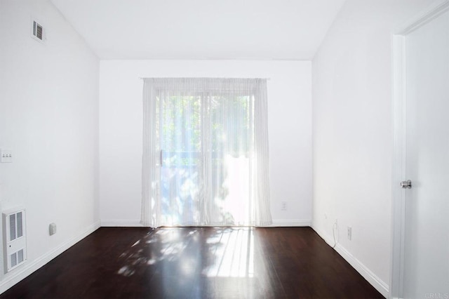 unfurnished room featuring vaulted ceiling and dark hardwood / wood-style flooring