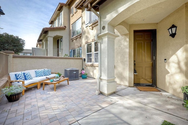 property entrance with central AC unit, a patio, and an outdoor hangout area