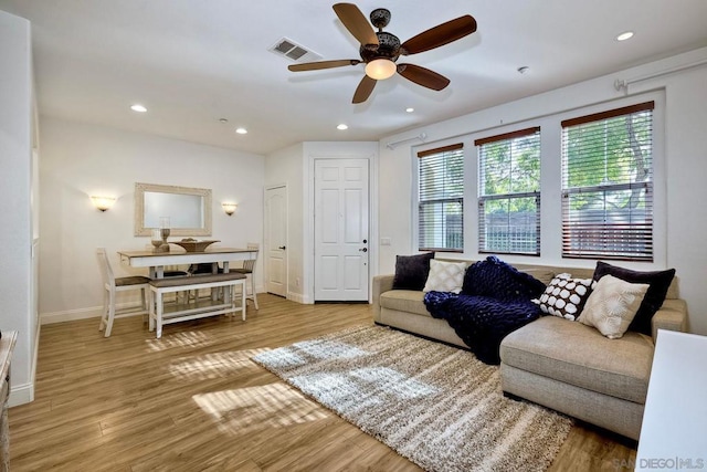 living room with ceiling fan and light hardwood / wood-style floors