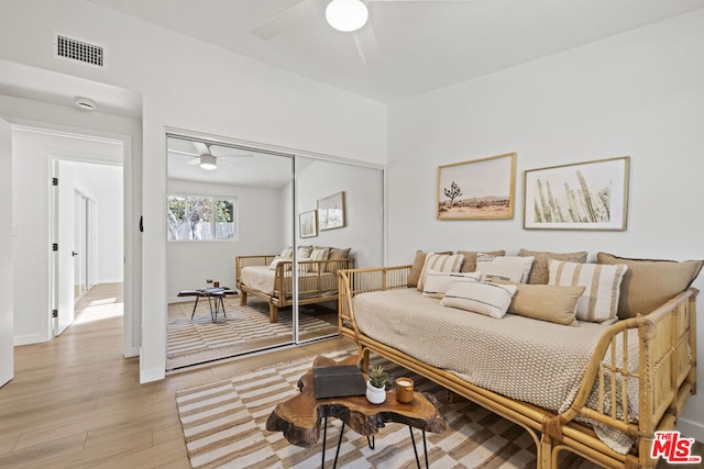 living room with light wood-type flooring and ceiling fan