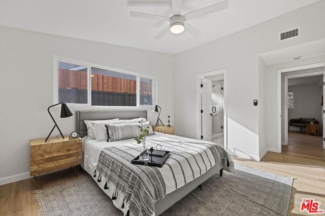 bedroom with ensuite bathroom, ceiling fan, and hardwood / wood-style flooring