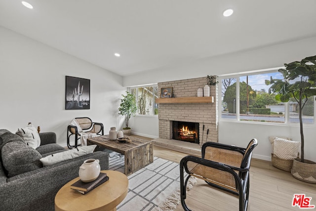 living room featuring a fireplace, light hardwood / wood-style flooring, and plenty of natural light