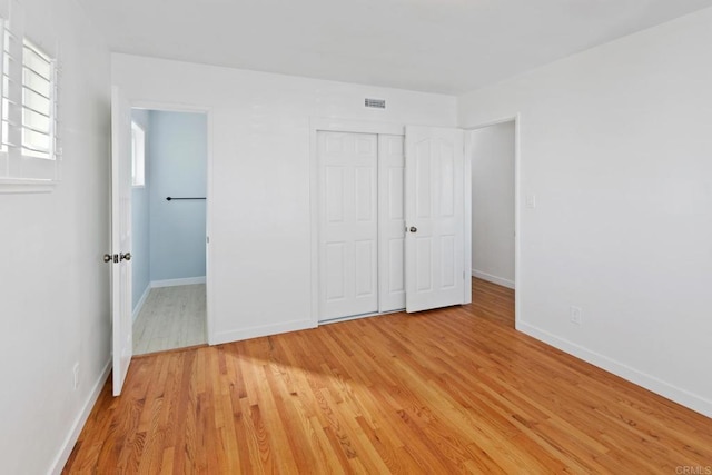 unfurnished bedroom featuring light hardwood / wood-style floors and a closet