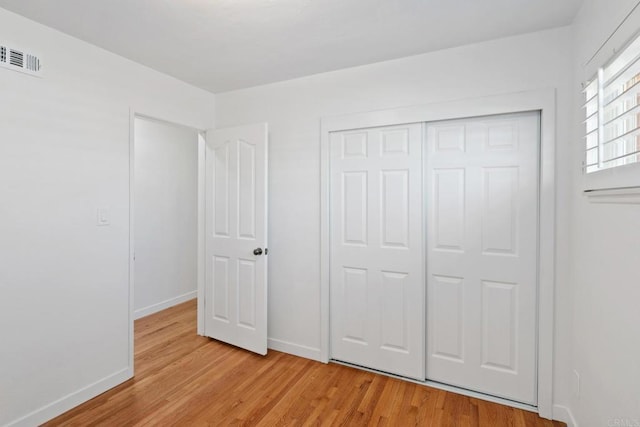 unfurnished bedroom with a closet and light hardwood / wood-style flooring