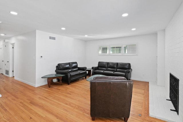 living room featuring hardwood / wood-style flooring and a large fireplace