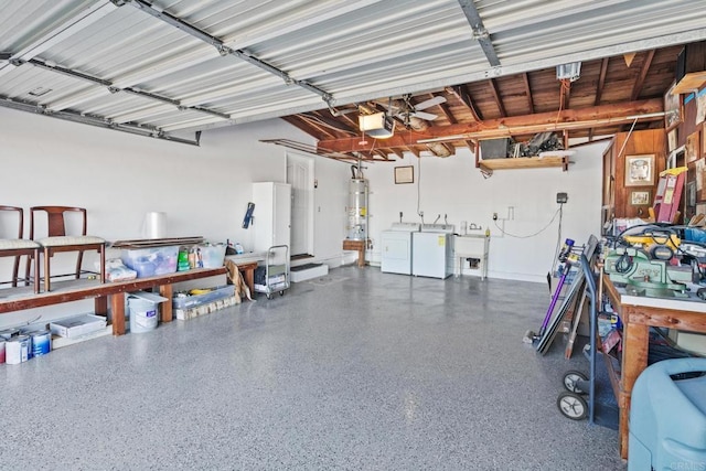 garage featuring independent washer and dryer, a garage door opener, sink, and water heater