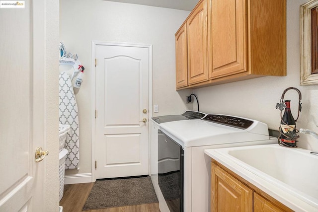 washroom with washer and dryer, dark hardwood / wood-style flooring, sink, and cabinets