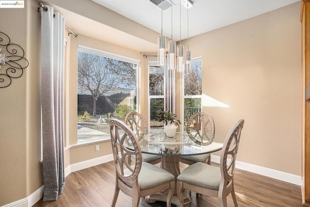 dining space featuring a healthy amount of sunlight and hardwood / wood-style flooring