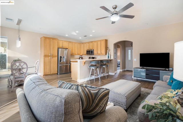 living room with ceiling fan and light hardwood / wood-style flooring