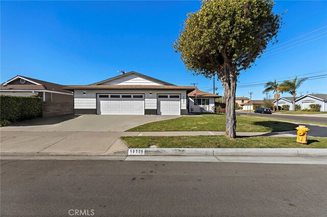 ranch-style home featuring a garage and a front lawn